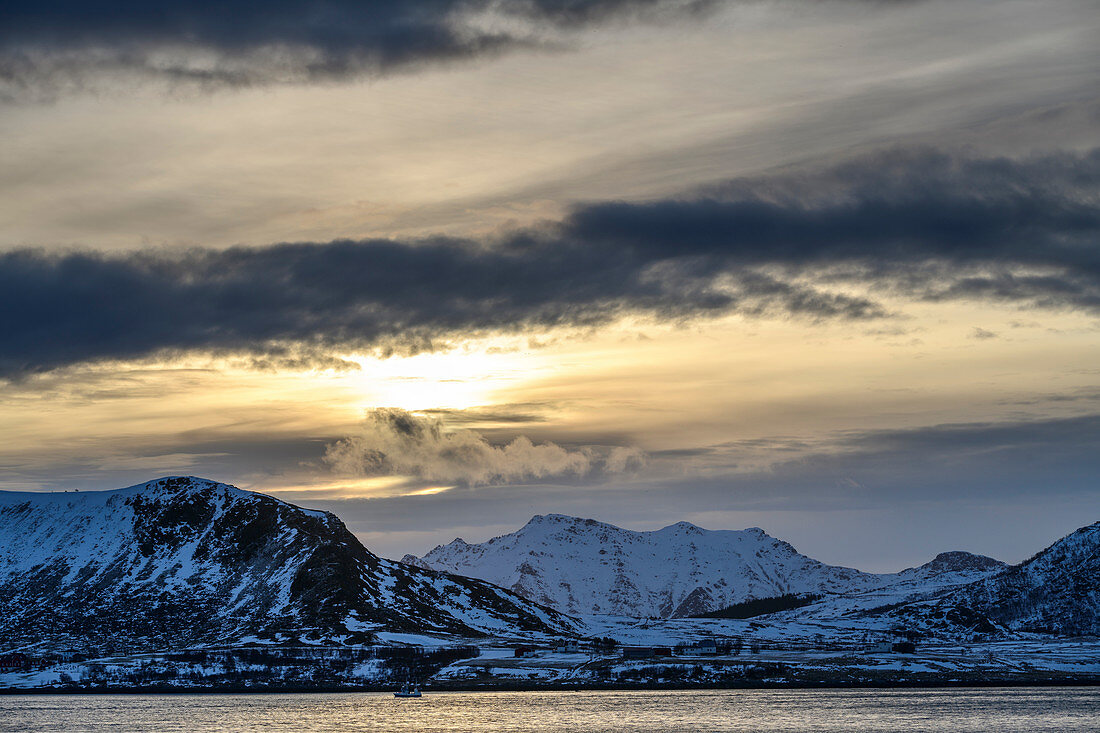 Schlechtwetterwolken über Küste und verschneiten Bergen, Napp, Lofoten, Nordland, Norwegen