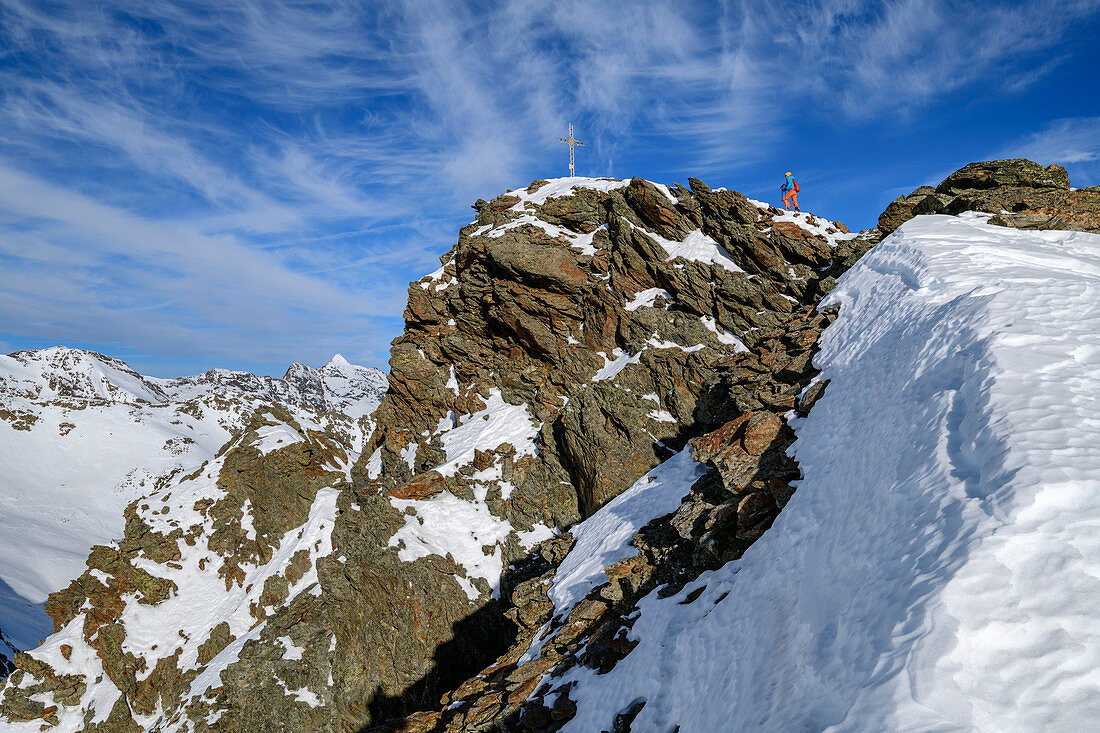 Frau auf Skitour steigt auf felsigen Gipfel des Plereskopfs auf, Plereskopf, Matscher Tal, Ötztaler Alpen, Südtirol, Italien 