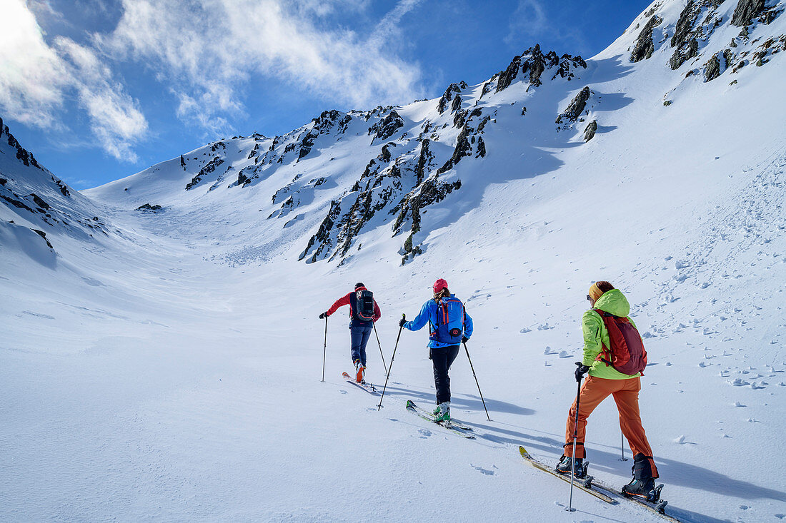 Drei Personen auf Skitour steigen durch Tal auf, Pangert, Tuxer Alpen, Tirol, Österreich