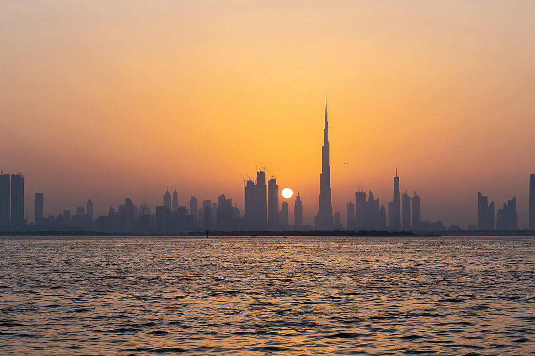 Die Skyline der Stadt mit der untergehenden Sonne, Dubai, VAE