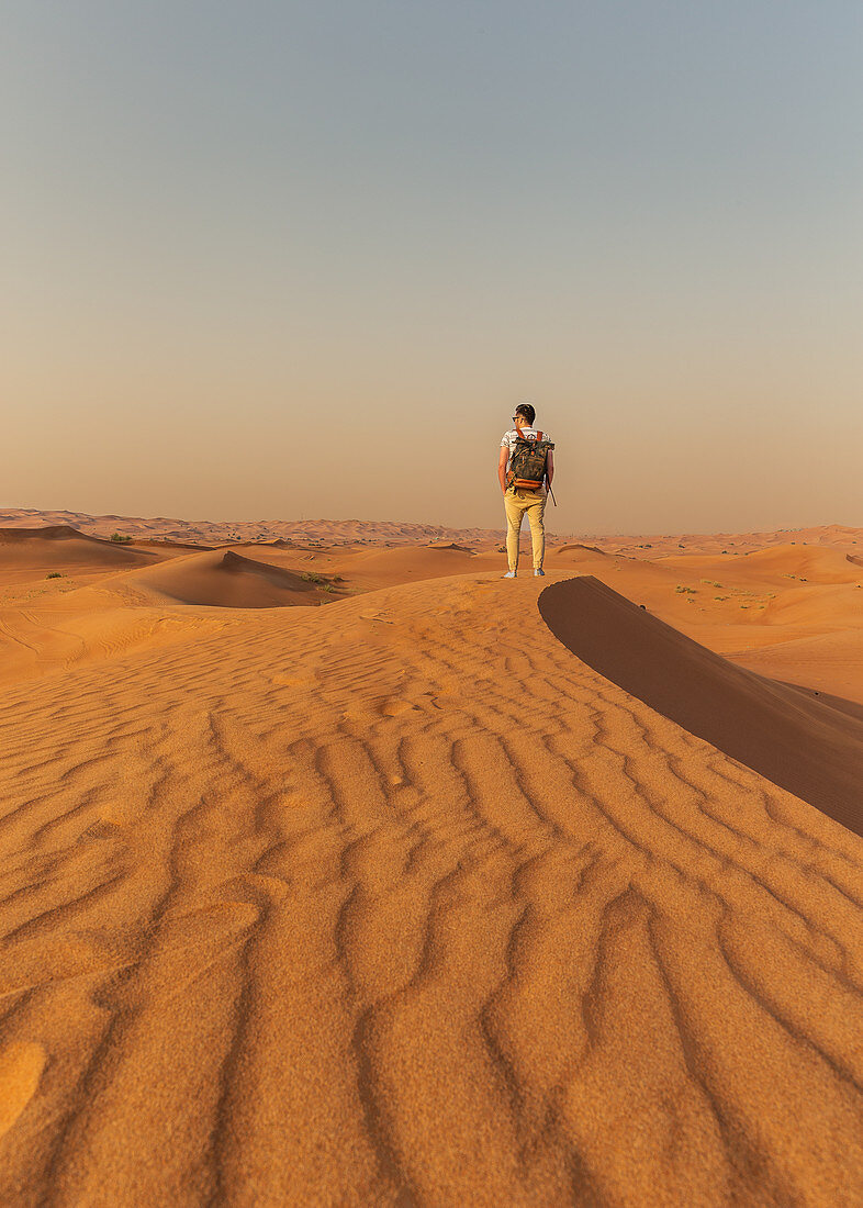 Traveler in the desert dunes off Dubai, UAE