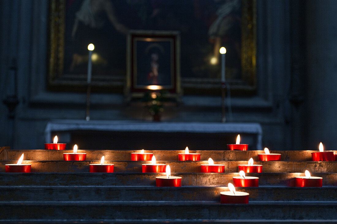Burning candles in the Basilica Santa Croce in Florence, Italy