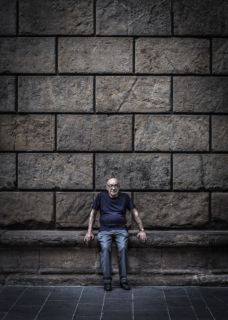 Einheimischer sitzt auf einer Bank in Florenz, Italien