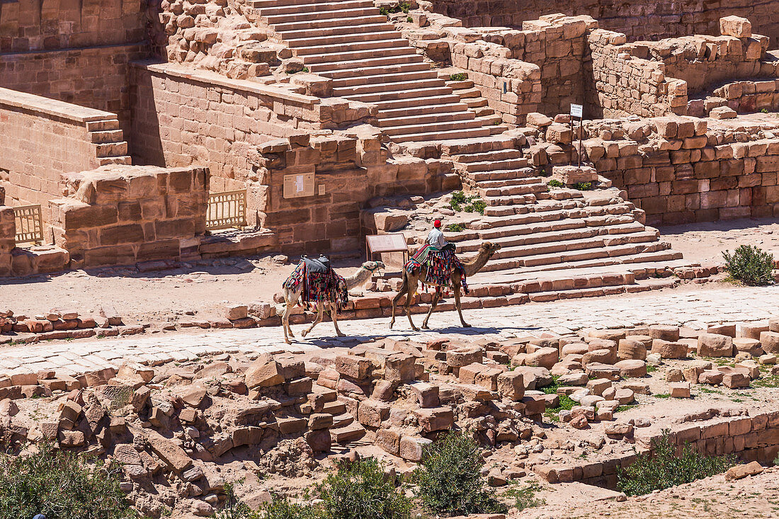 Beduine reitet mit seinen zwei Kamelen durch die Ruinen von Petra, Jordanien