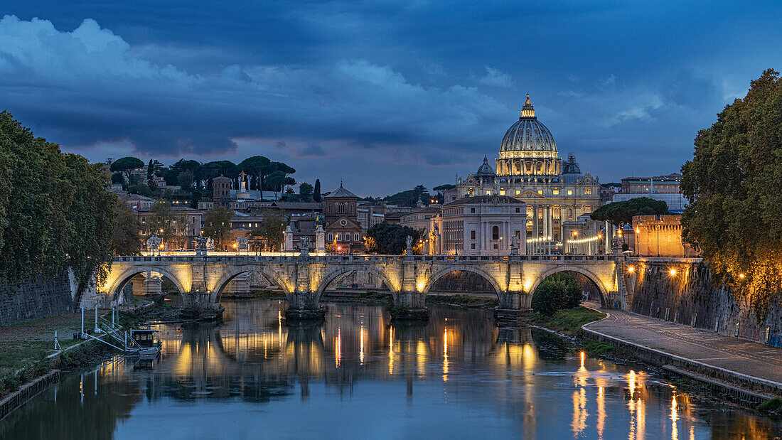 Blick auf den beleuchteten Petersdom und die Engelsbrücke kurz nach Sonnenuntergang, Rom, Italien