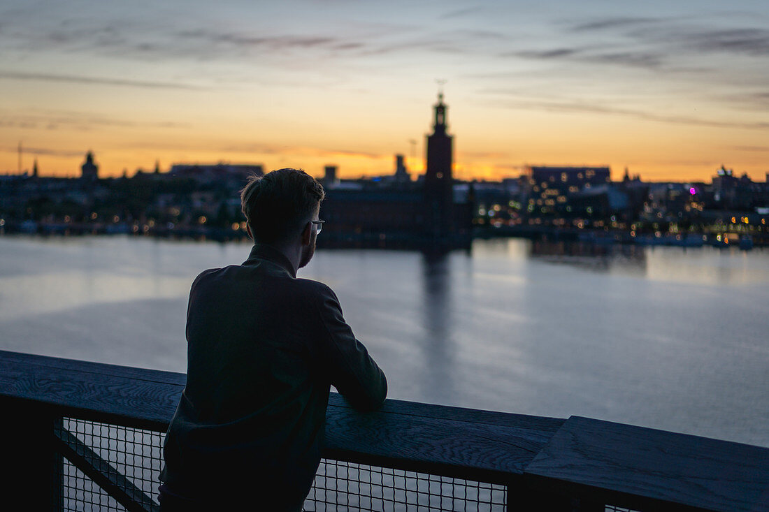 Tourist mit Blick auf den Sonnenuntergang über Stockholm, Schweden
