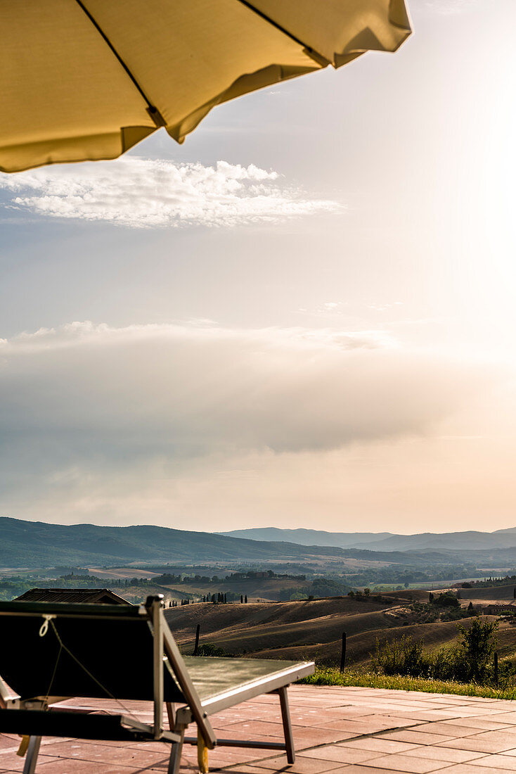 Sunbed and umbrella by a pool, Buonconvento, Tuscany, Italy