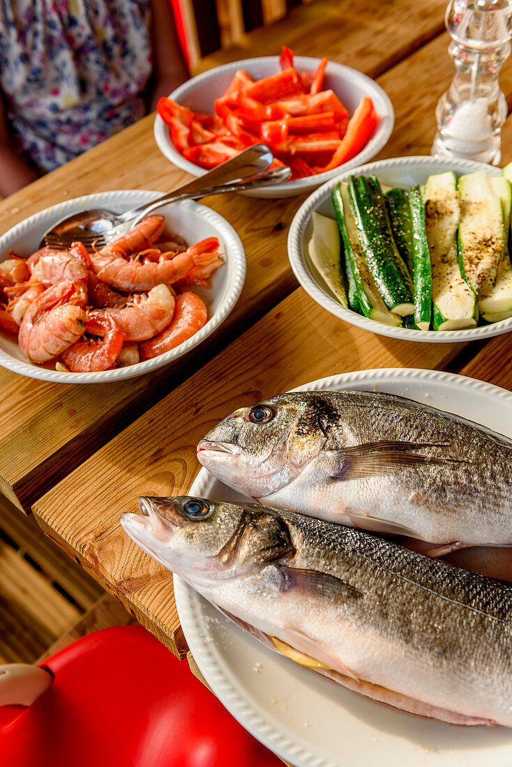 Frischer Fisch und Gemüse auf einem Holztisch