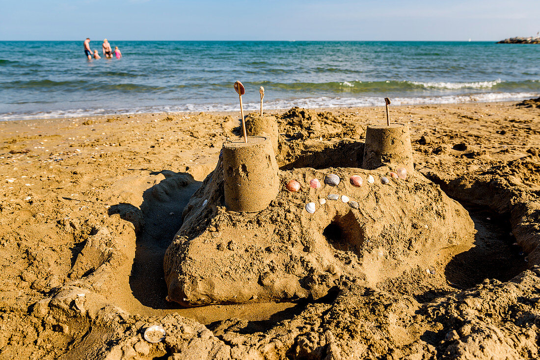 Sand castle with sand toys on sandy beach in Veneto, Italy