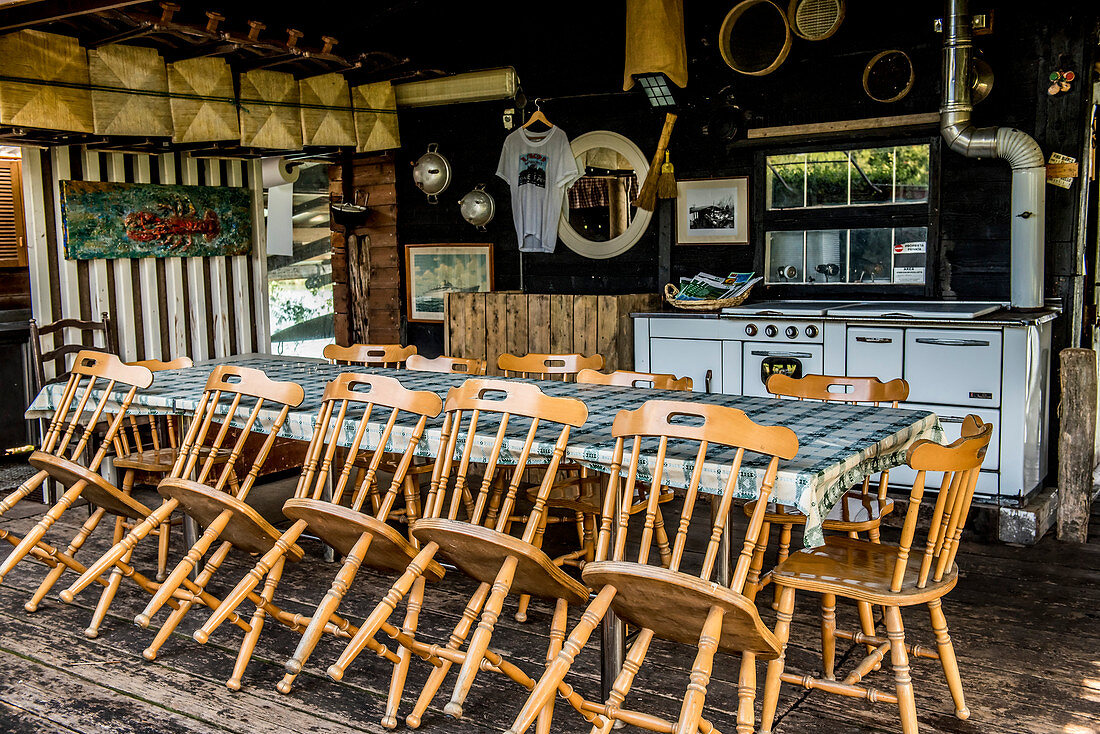 Table with wooden chairs in a closed tourist restaurant, Italy
