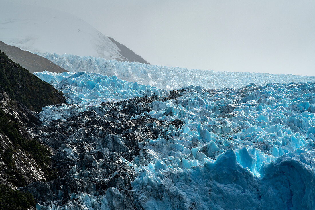 Ansicht der linken Seite des Gletschers mit dunkler Moräne auf der Oberfläche, Garibaldi-Gletscher, nahe Beagle-Kanal, Alberto de Agostini-Nationalpark, Magallanes y de la Antartica Chilena, Patagonien, Chile, Südamerika