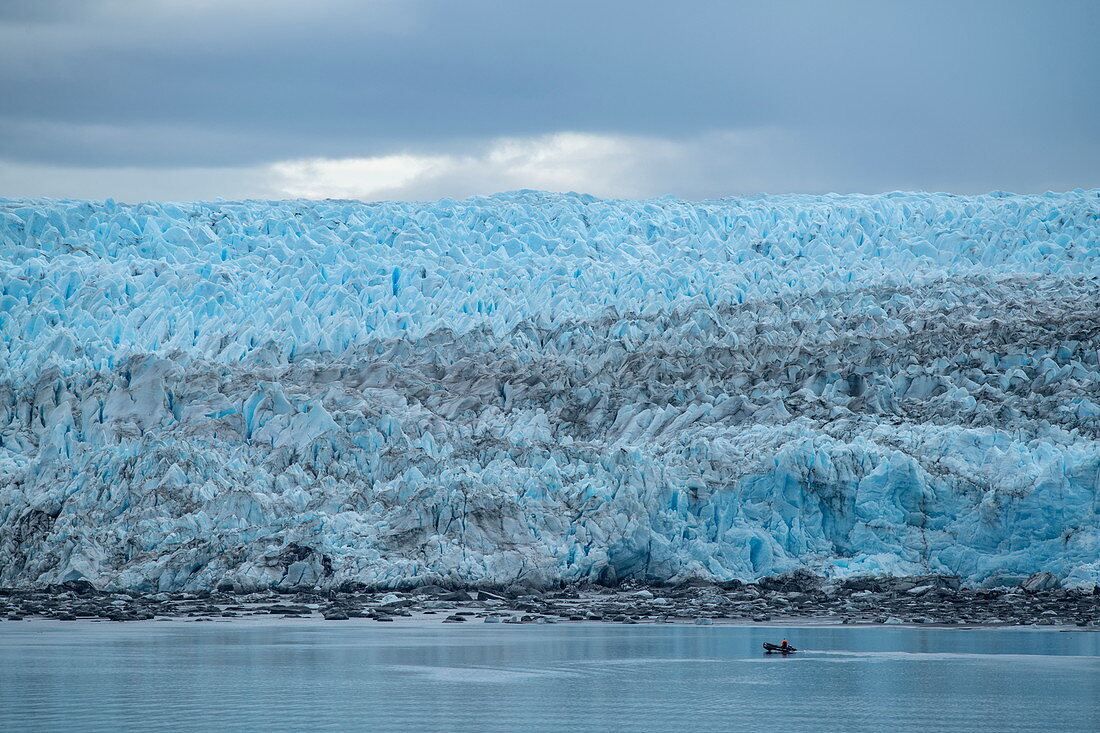 Ein Zodiac-Schlauchboot passiert die Vorderkante des massiven Gletschers Pio XI, Magallanes y de la Antartica Chilena, Patagonien, Chile, Südamerika