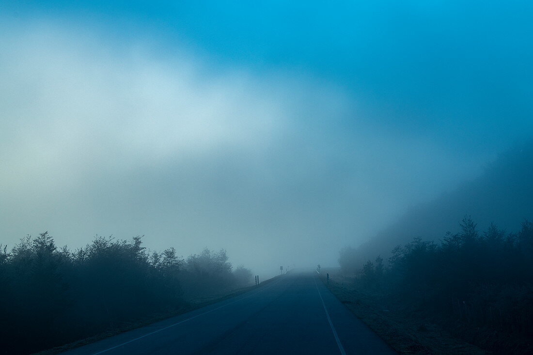 Eerie view of a foggy mountain road, near Puerto Chacabuco, Aysén, Patagonia, Chile, South America