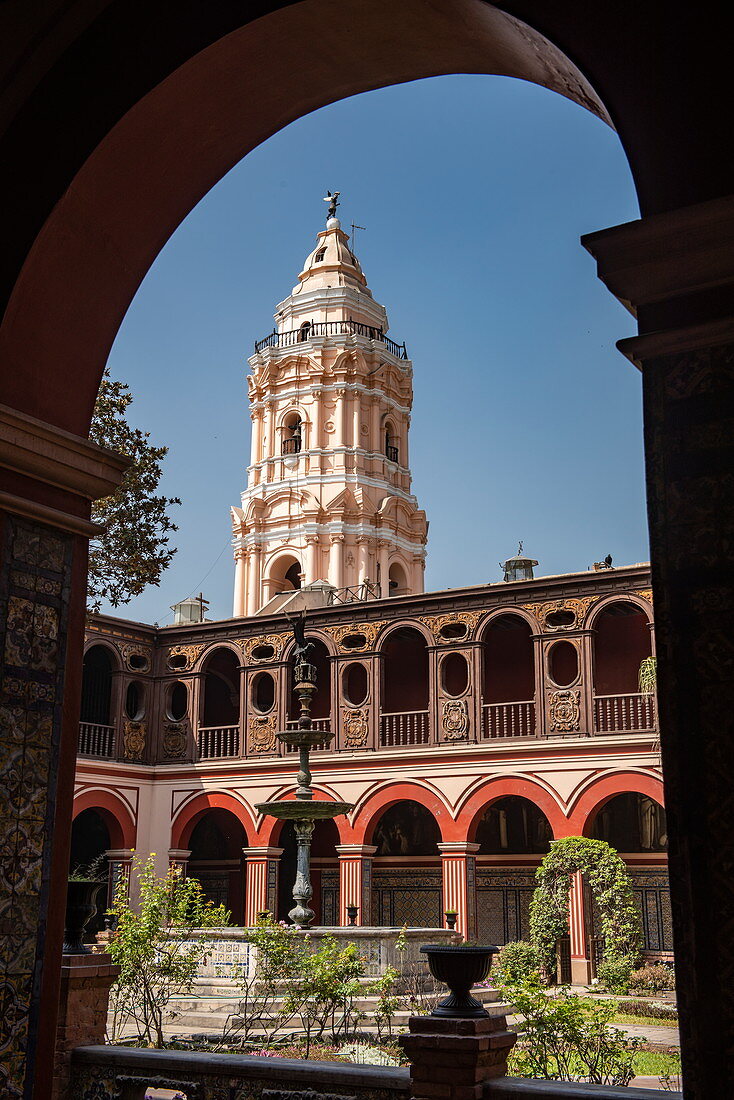 View of a nearby tower through an archway in the courtyard of the 16th century Casa Aliga, Lima, Lima, Peru, South America