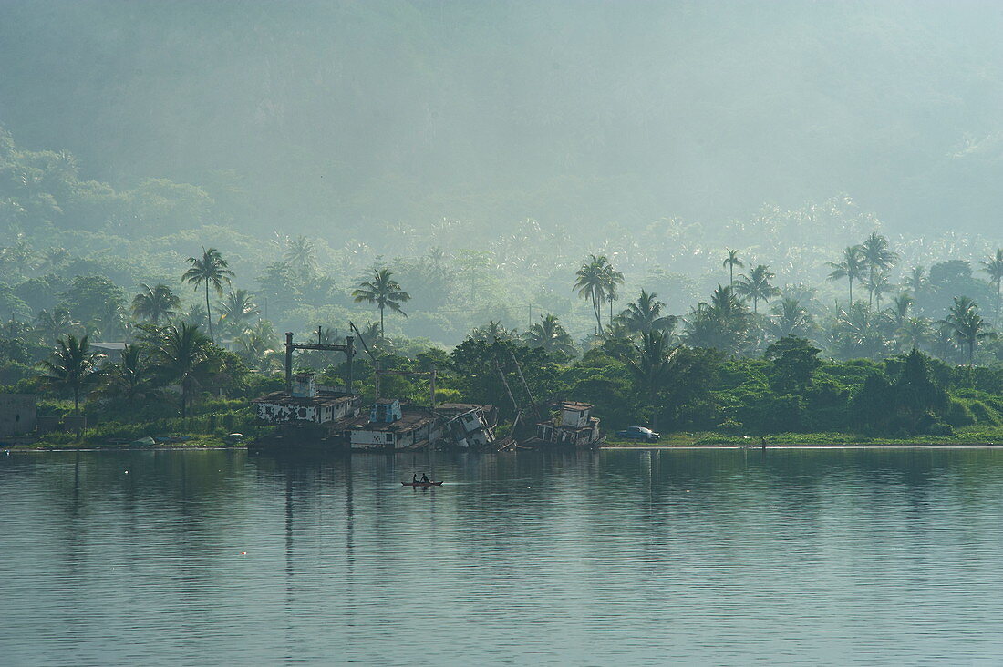 Rauchschleier von einem Vulkan hängt über Palmen entlang der Küste, Rabaul, Provinz Ost-New Britain, Papua-Neuguinea, Südpazifik