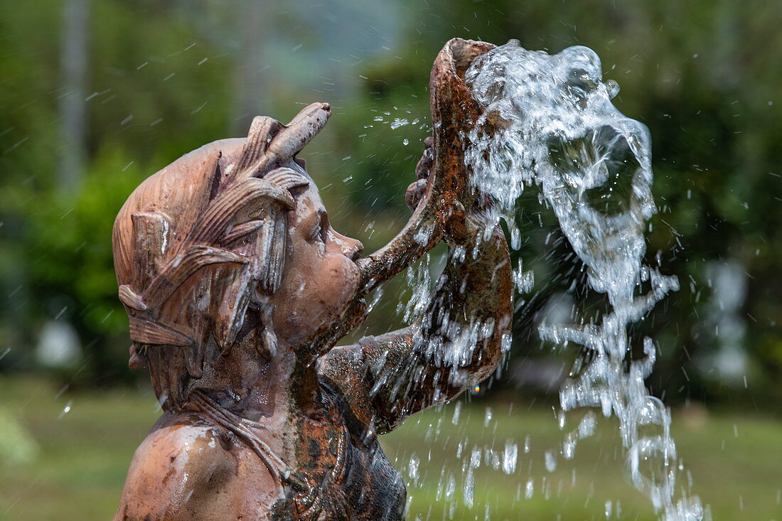 A fountain shows the head and shoulders of a boy blowing a horn from which water emerges, Maracas Bay, Trinidad, Trinidad and Tobago, Caribbean