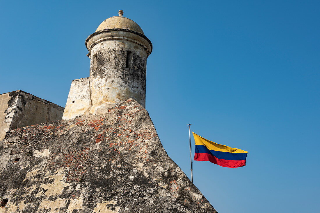 Die Nationalflagge weht von den Stadtmauern des historischen und imposanten Castillo San Felipe de Barajas, Cartagena, Bolivar, Kolumbien, Südamerika