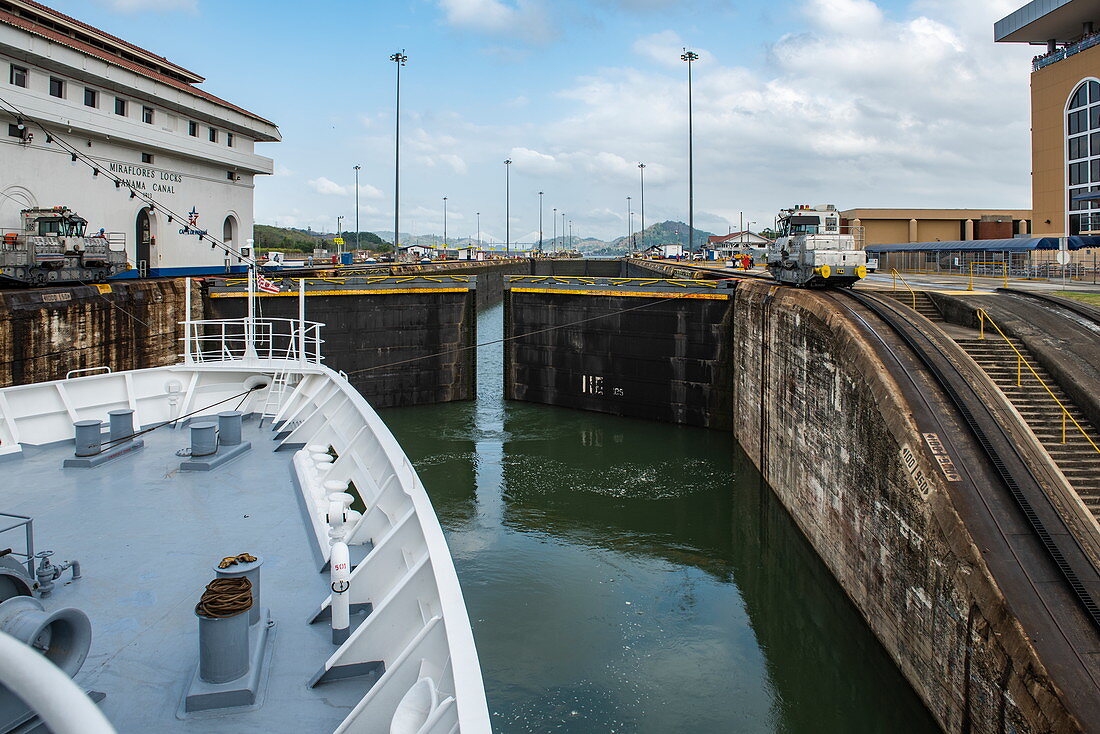 An expedition cruise ship in the Panama Canal is preparing to leave the Miraflores Lock with the grandstand on the right, near Panama City, Panama, Central America
