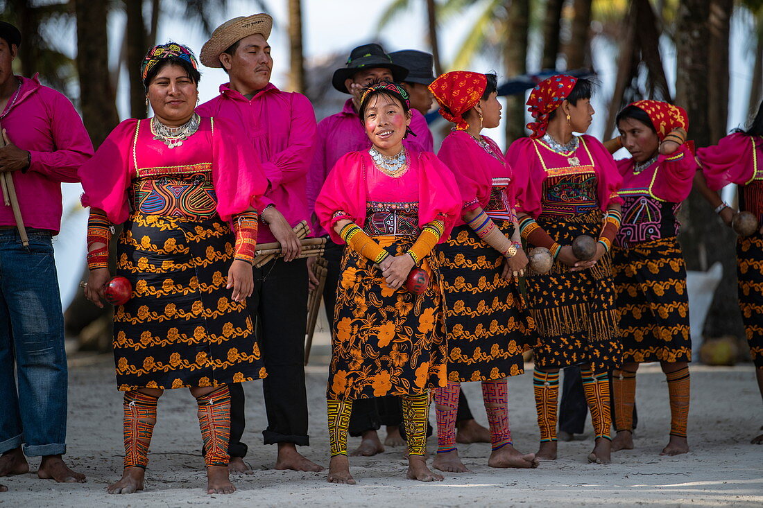 A group of Guna (formerly Kuna) natives in bright, traditional costumes prepares for a folklore dance, Isla Aroma, San Blas Islands, Panama, Caribbean
