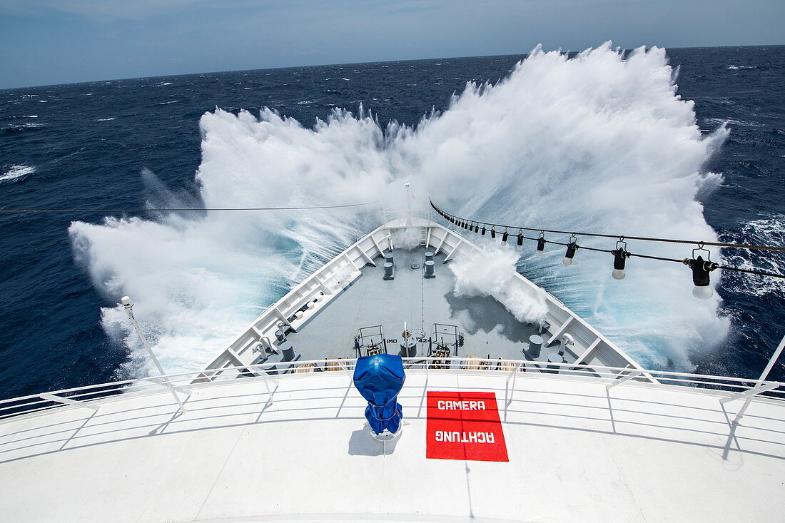 The front of an expedition cruise ship encounters a large wave and sends spray high over the prow, Atlantic Ocean, near Panama, Central America