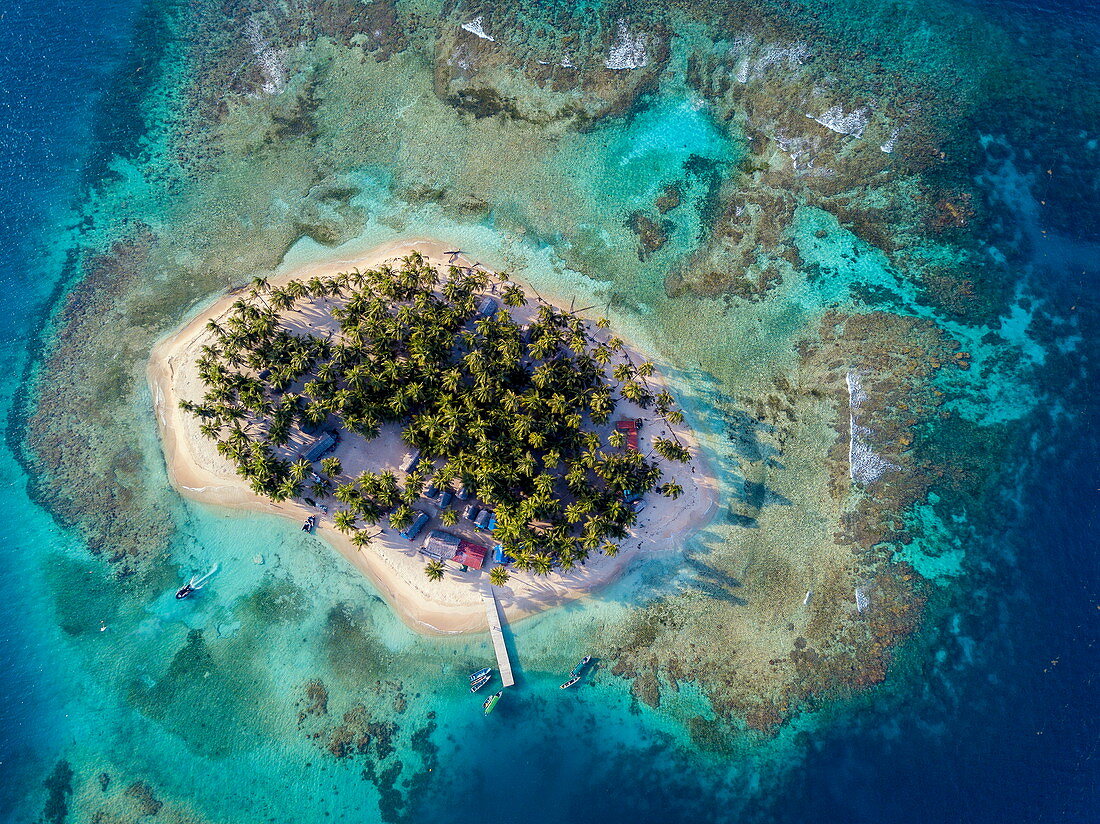Luftaufnahme der Insel und der umliegenden Riffe und des Wassers in verschiedenen Blau- und Blaugrüntönen, Isla Aroma, San Blas-Inseln, Panama, Karibik