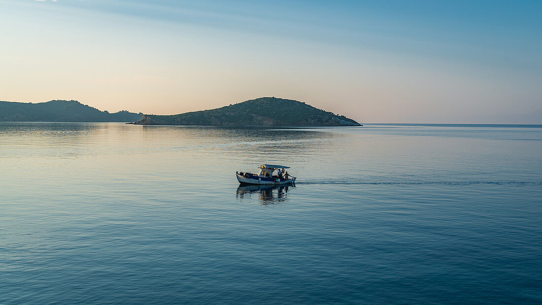 Fishing boat goes out to sea early in the morning, Skiathos, Greece