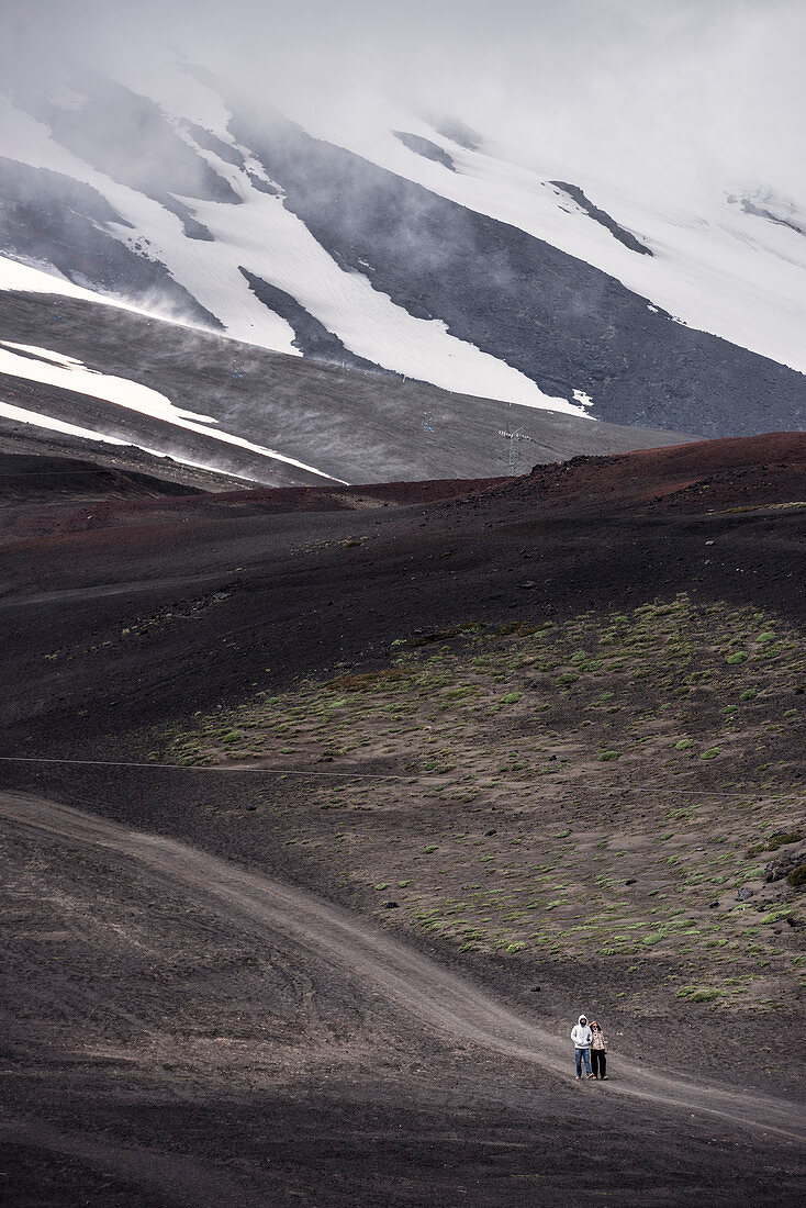 Personen laufen auf der Vulkanasche des Osorno Vulkan spazieren, Region de los Lagos, Chile, Südamerika