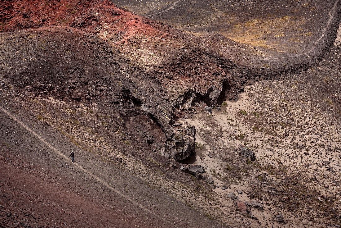 Detail of a person running on the volcanic landscape of the Osorno, Region de los Lagos, Chile, South America