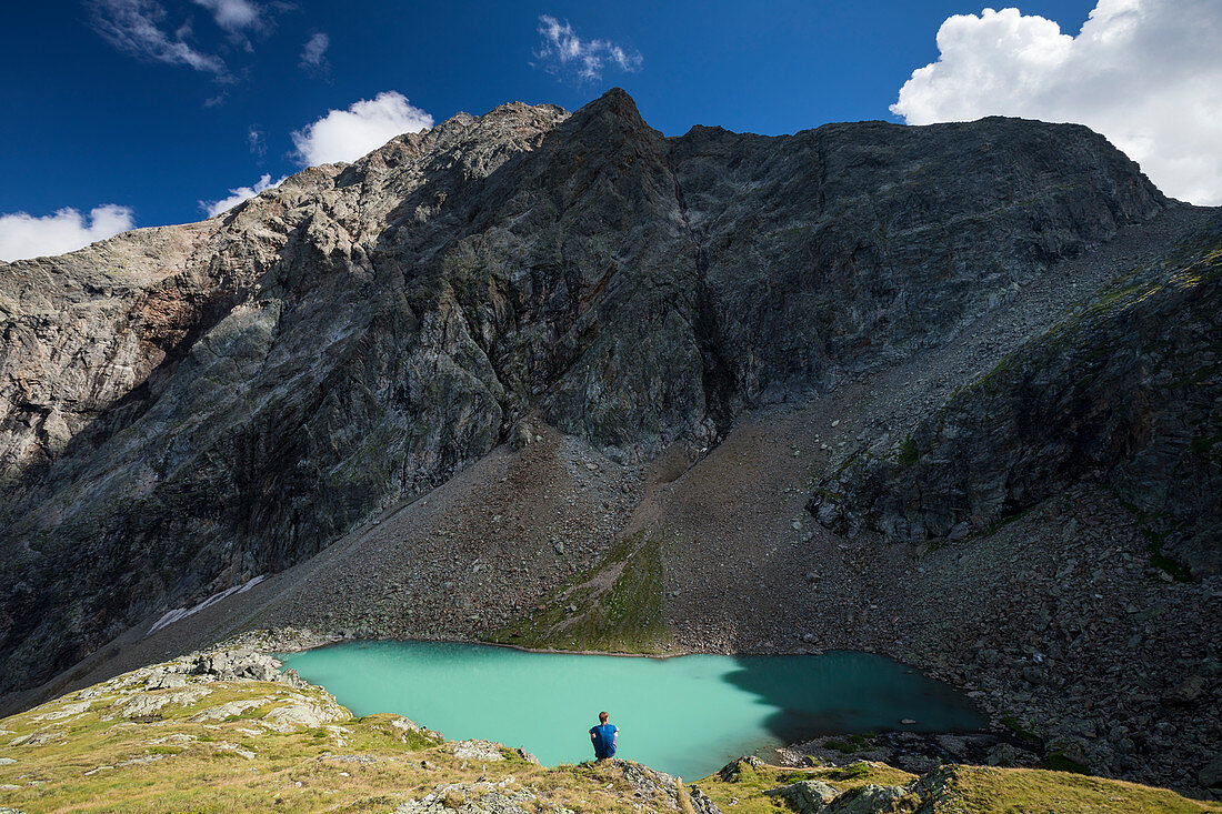 Man at mountain lake Vorderee in front of rocky backdrop in Gradental, Hohe Tauern National Park, Austria