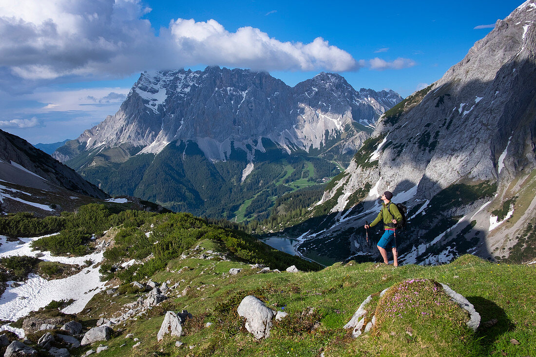 Hikers in the Seebensee panorama in spring with Zugspitze, clouds in the sky, Ehrwald Austria