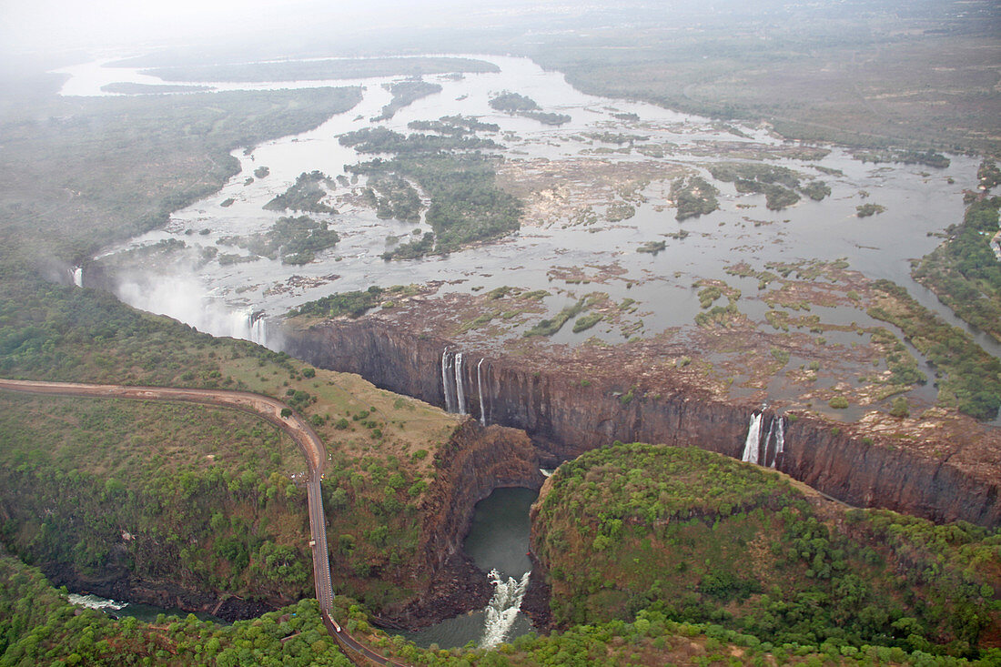 Schluchttal des Sambesi-Flusses, in voller Länge des Victoriafall-Wasserfalls und der Victoriafall-Brücke, Simbabwe/Sambia.
