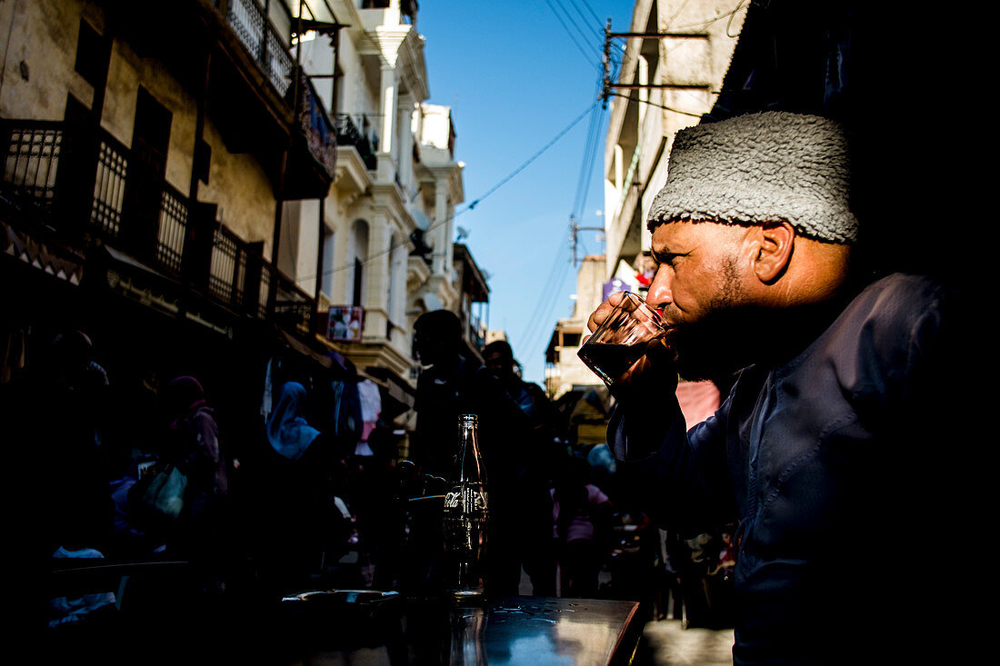 Marokko, Fes - 6. Oktober 2013. Ein Einheimischer trinkt eine Coca-Cola in einem Café in einer kleinen Straße von Fez