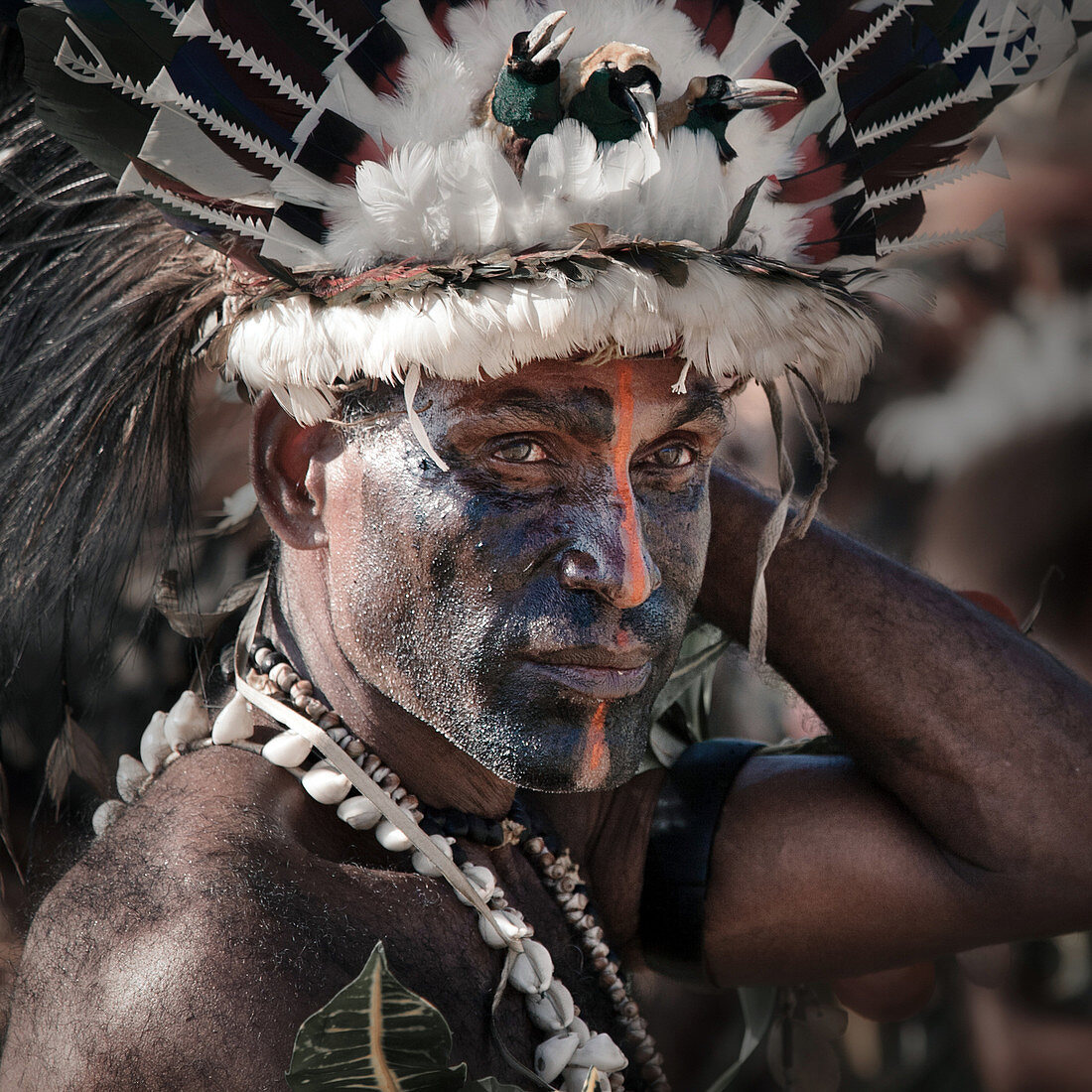 Alotau, Papua New Guinea - November 6, 2010: A man with tribal face painting is wearing hat with feathers at the Kenu and Kundu Canoe Festival.