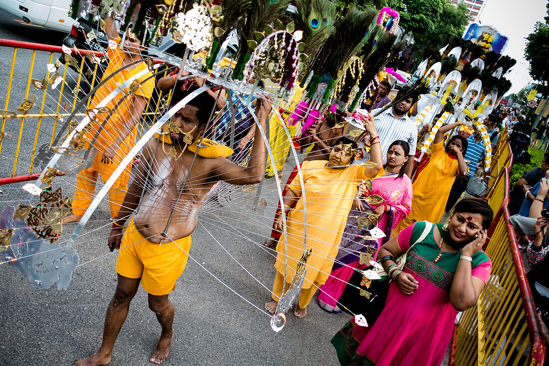 Singapur - 17. Januar 2014: Eine große Gruppe von Tamilen feiert das Hindu-Fest Thaipusam auf der Straße. Piercings auf dem Körper demonstrieren ihren Glauben während des Festivals.