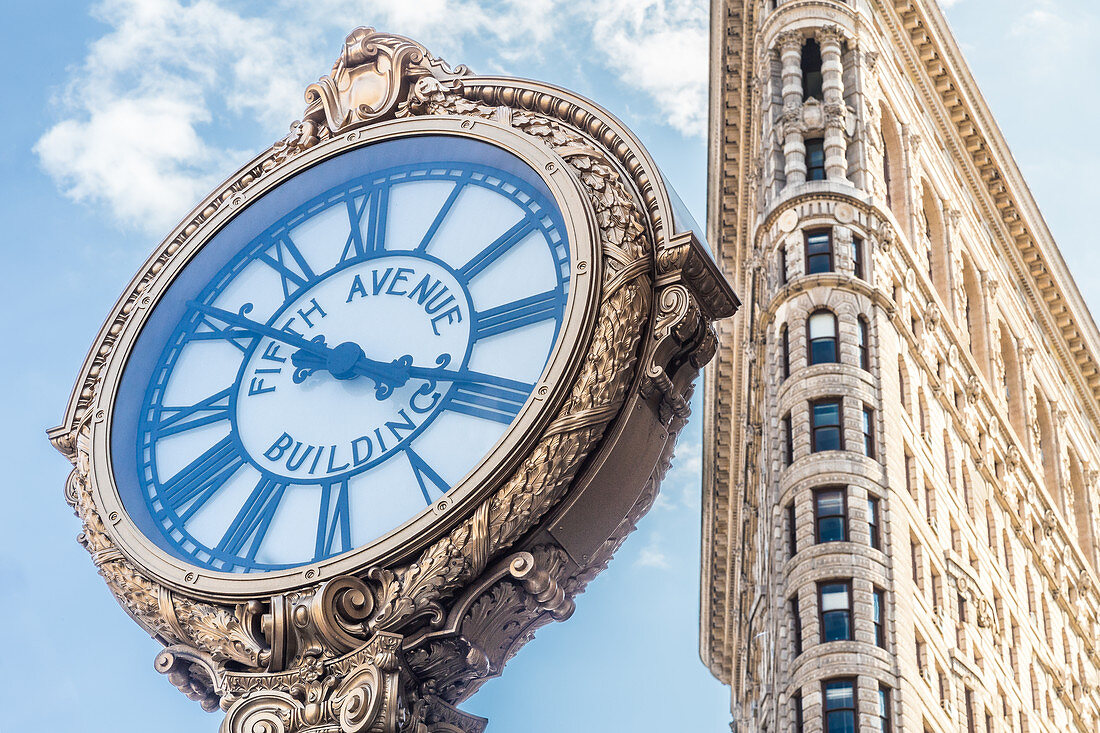 Golden clock in front of the Flatiron Building, New York City, USA