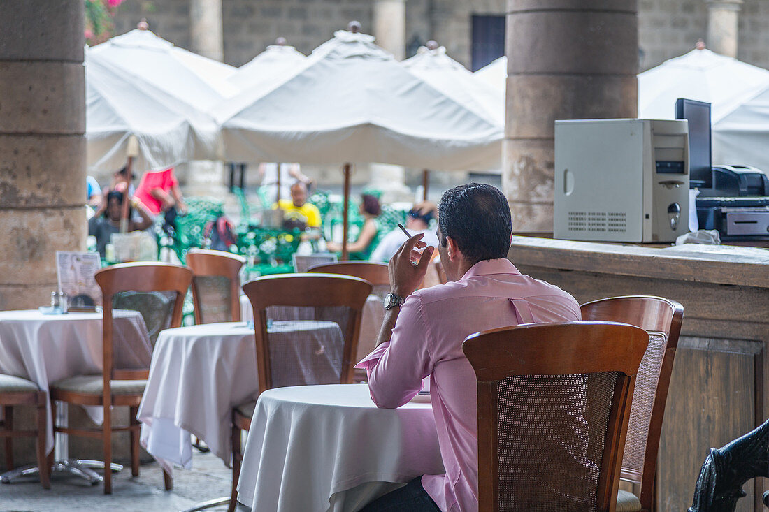 Man drinks his coffee and smokes a cigarette, Havana, Cuba