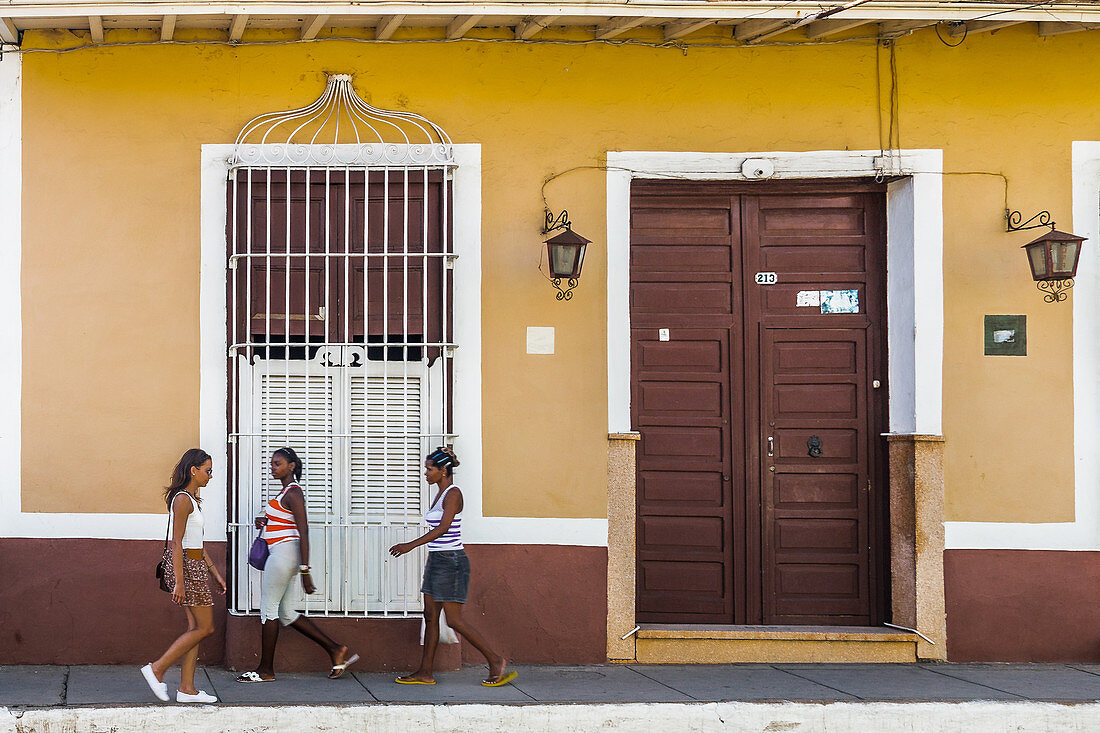 Drei Frauen gehen auf der Straße in Trinidad, Kuba