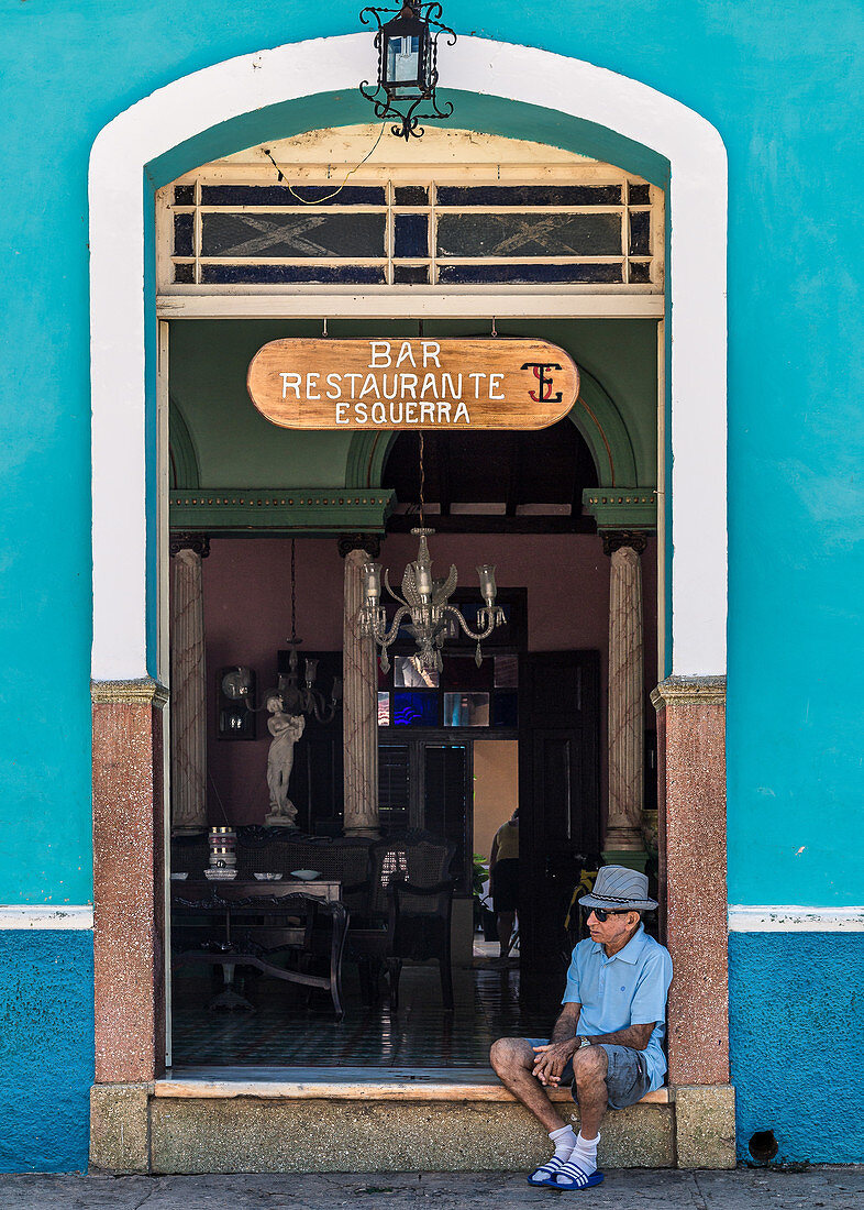 Kubaner sitzt vor einer Bar in Trinidad, Kuba