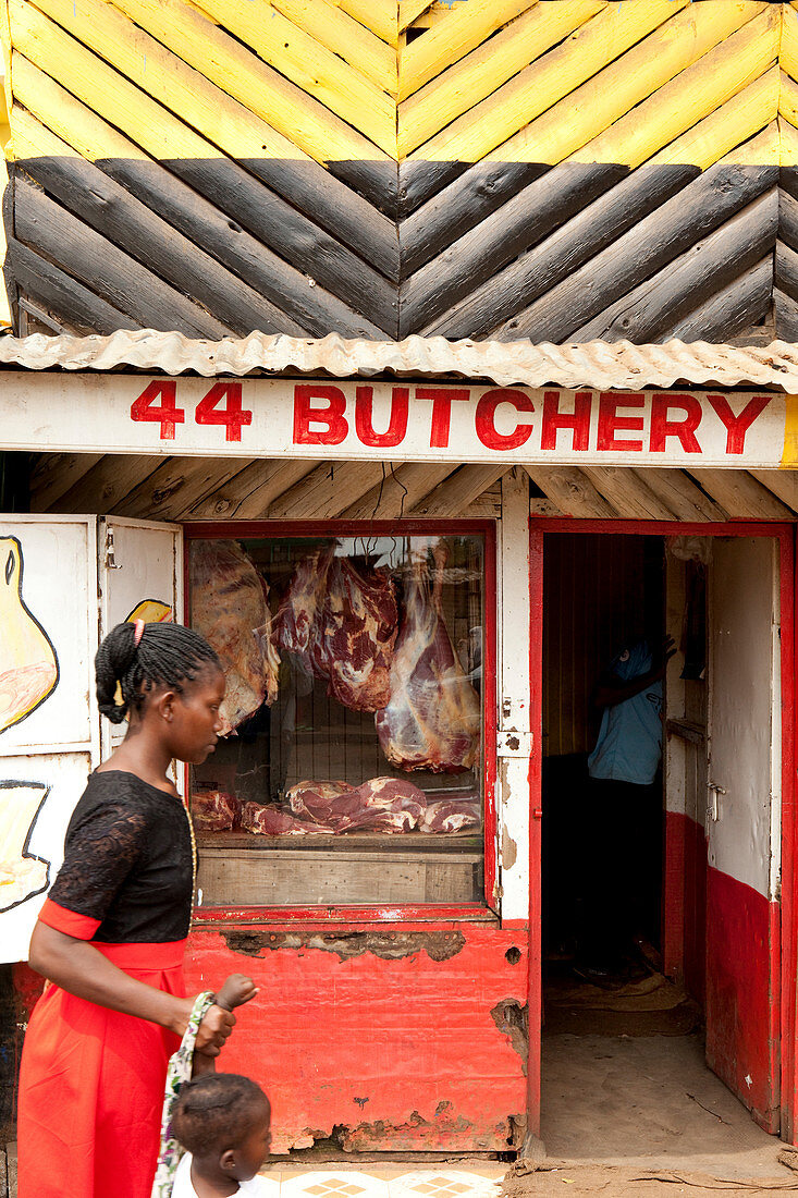 Kenyan woman with her child in front of a butcher shop in the slum, Eastleigh, Nairobi, Kenya