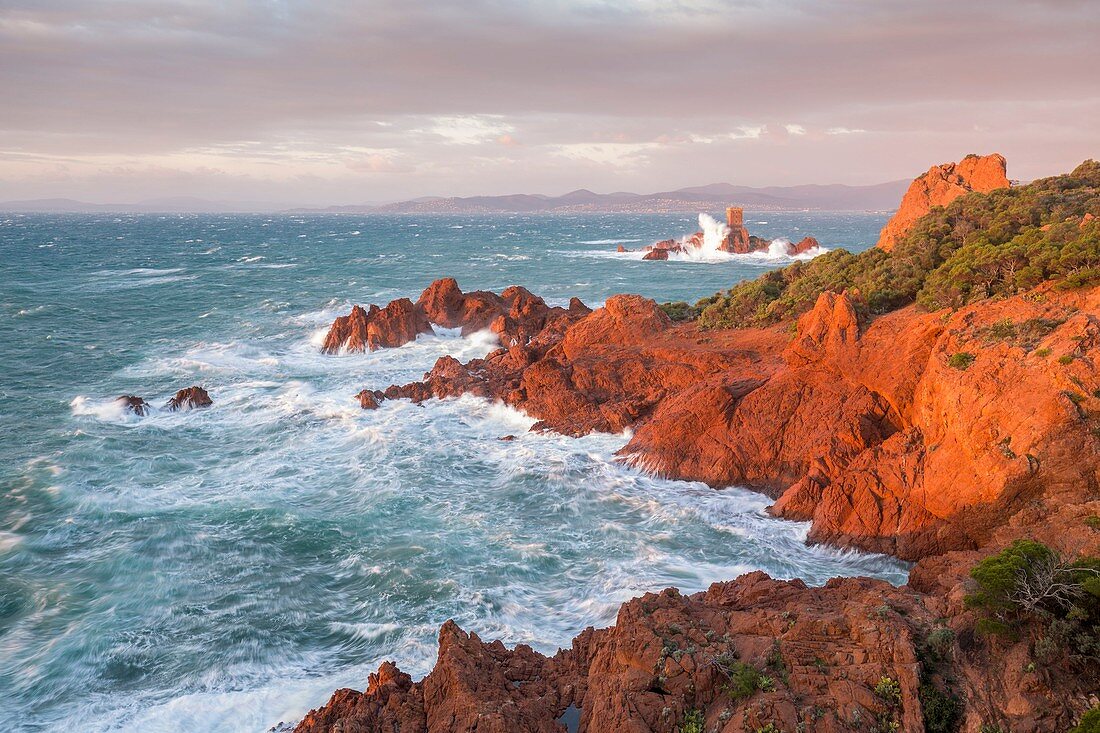 Frankreich, Var, Saint-Raphaël, starker Wellengang und starker Wind auf den roten Klippen vulkanischen Ursprungs (Rhyolith) des Cap du Dramont, im Hintergrund der Turm der Ile d'Or