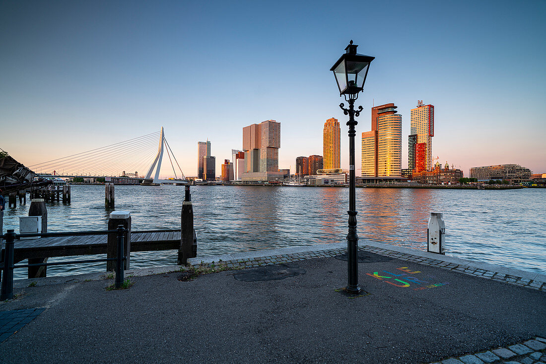 Abendlicher Blick über die Neue Maas auf die Erasmusbrücke und die Skyline am Cruise Terminal in Rotterdam, Niederlande