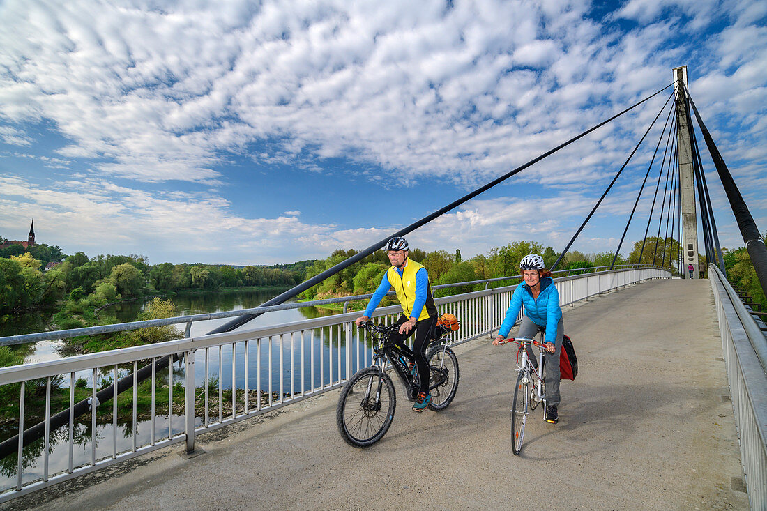 Man and woman ride a bike over the Charbonniere-les-Bains bridge, Danube bike path, Bad Abbach, Lower Bavaria, Bavaria, Germany