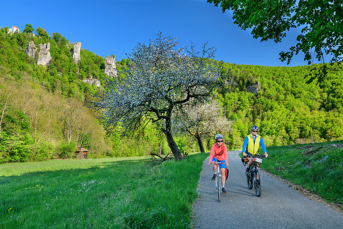 Man and woman ride a bike through the Upper Danube Valley, near Beuron, Upper Danube Valley, Danube Cycle Path, Baden-Württemberg, Germany
