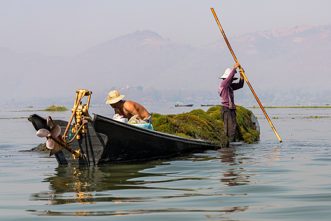 Fischer mit Stöcken auf kleinem Boot am Inle See, Heho, Myanmar