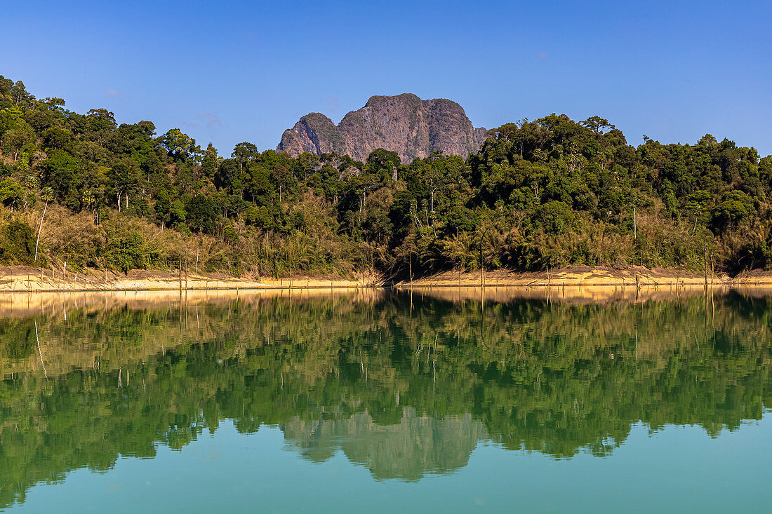Water reflections on calm water of Ratchaprapha Lake in morning light, Khao Sok National Park, Khao Sok. Thailand