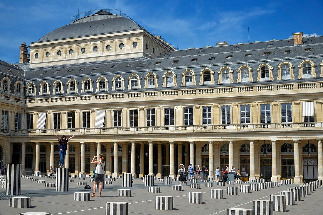 France, Paris, Royal Palace, young women taking picture in front of the Columns of Buren