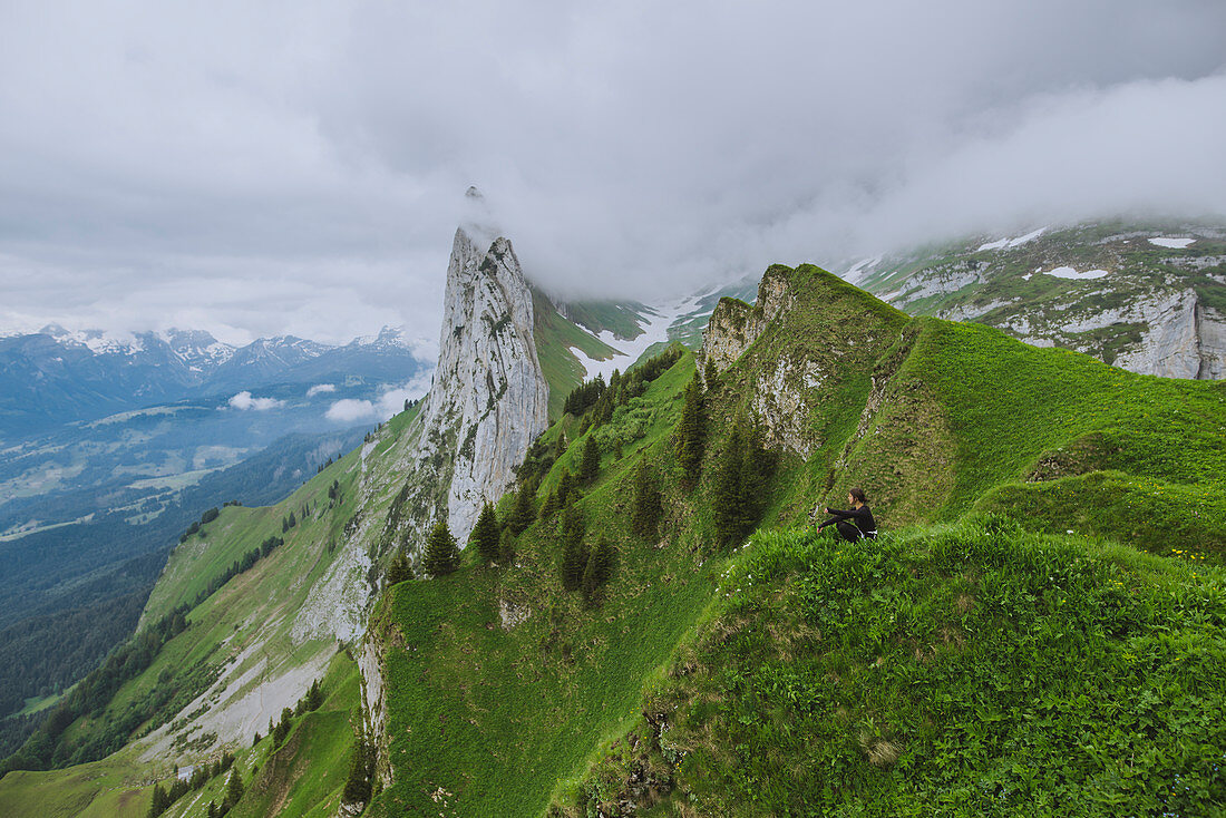 Frau sitzt auf einem Berg in Appenzell, Schweiz
