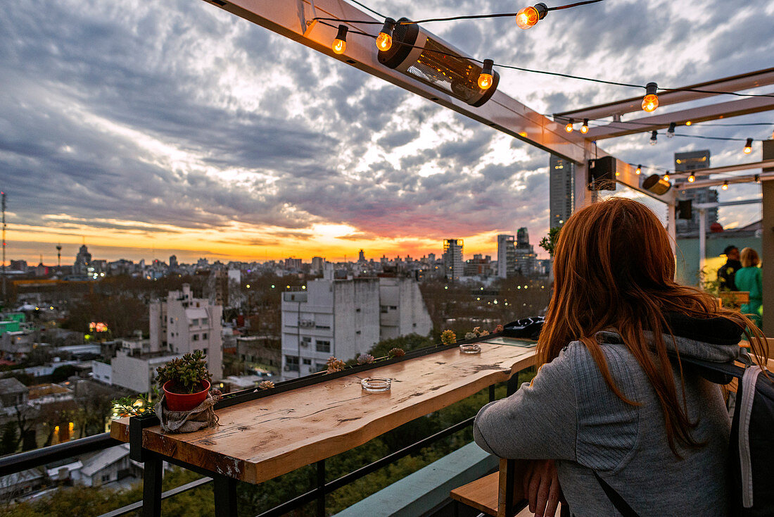 Frau beobachtet den Sonnenuntergang von einer Terrasse in der Stadtteil Palermo von Buenos Aires, Argentinien, Südamerika