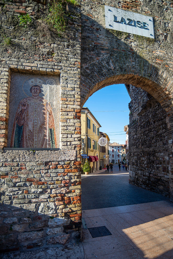Lazise sul Garda, Provinz Verona, Venetien, Italien, Europa, das mittelalterliche Tor, das den Eingang zum Stadtzentrum markiert, und ein altes Mosaik