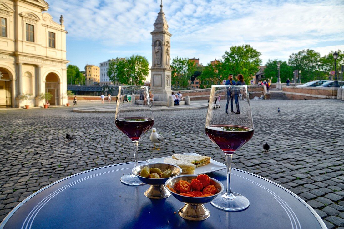 Italy, Lazio, Rome, historical centre listed as World Heritage by UNESCO, district of Campo di Fiori, Piazza di San Bartolomeo all' isola, glasses of wines with olives on a table on a paved place